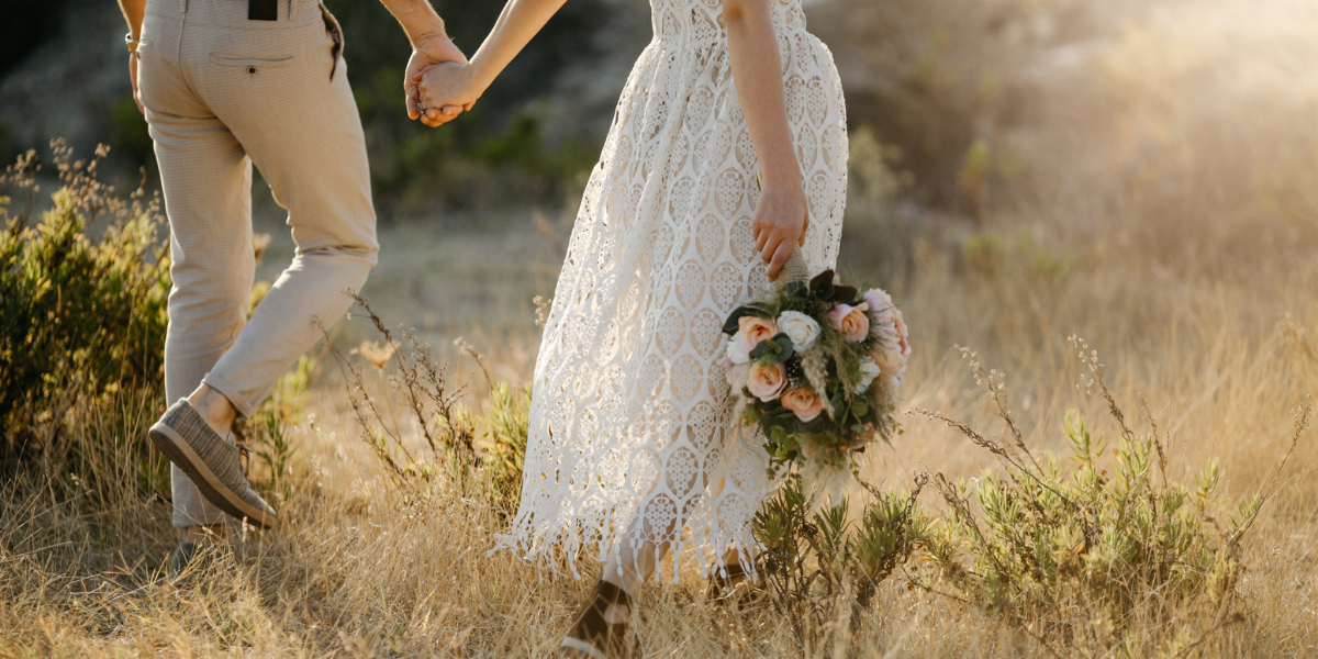 Bride & groom holding hands, bride holding bridal bouquet